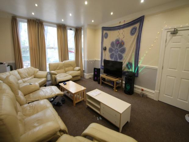 A spacious and well-lit living room featuring c...