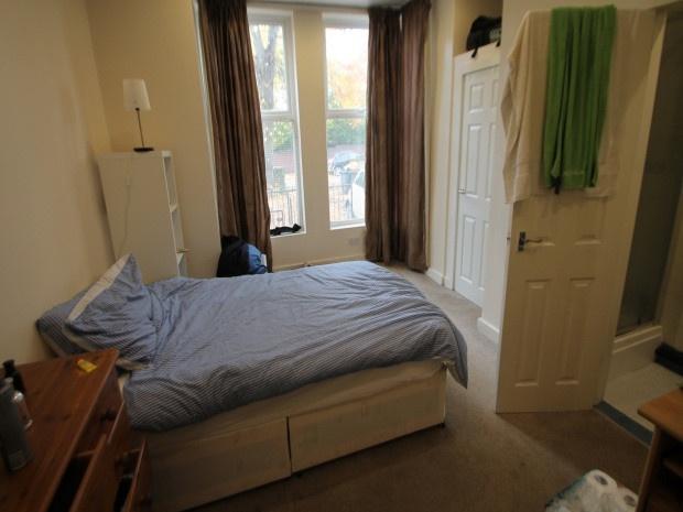 A cozy bedroom featuring a single bed, a window...