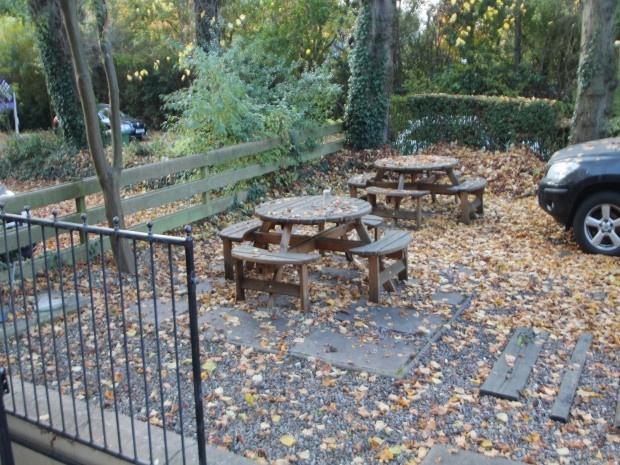 An outdoor garden area with several picnic tabl...