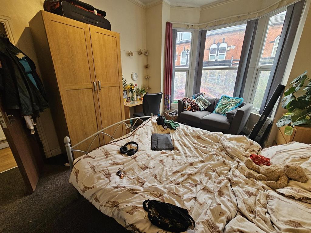 A cozy bedroom featuring a double bed, a large ...