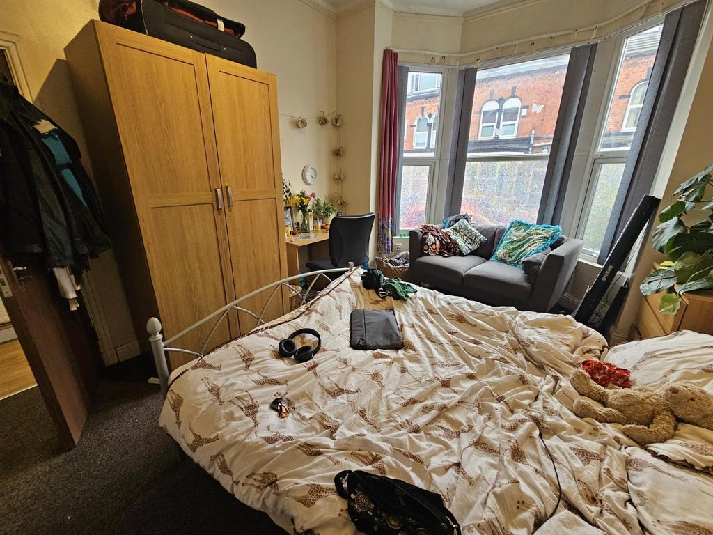 A cozy bedroom with a large window bathed in na...