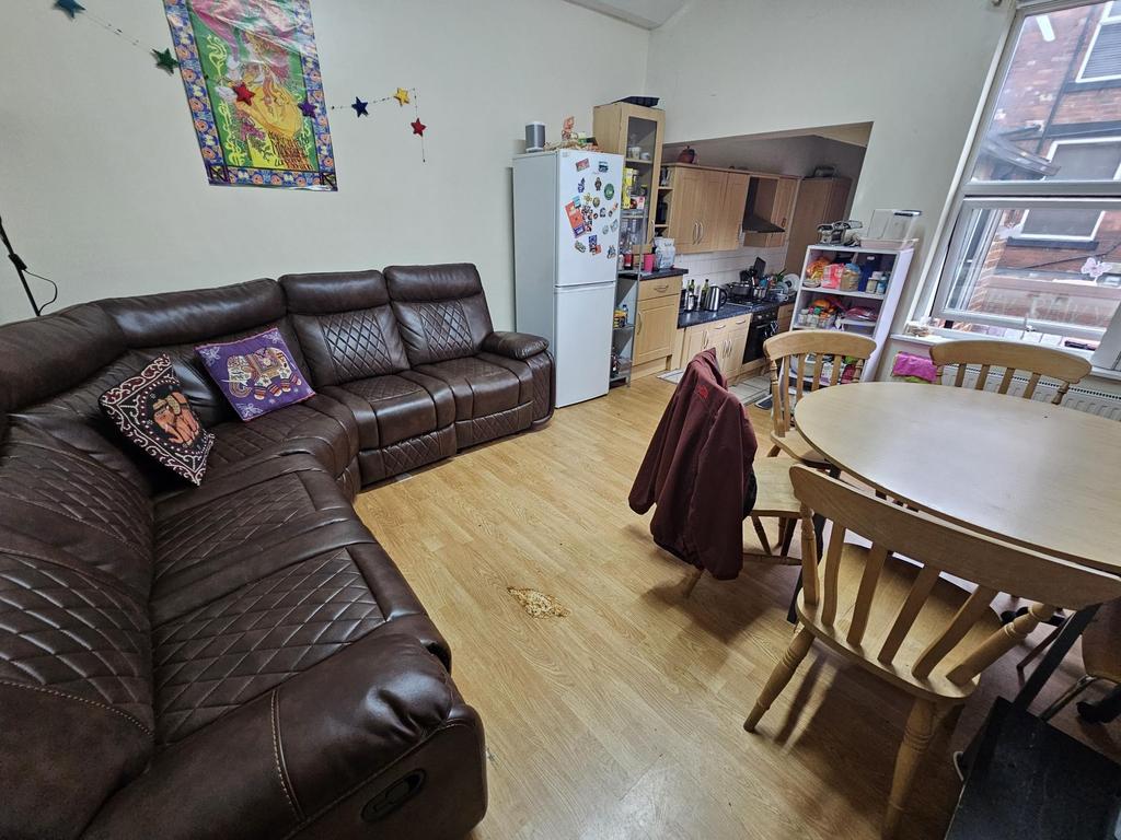 A spacious and well-lit living room featuring a...