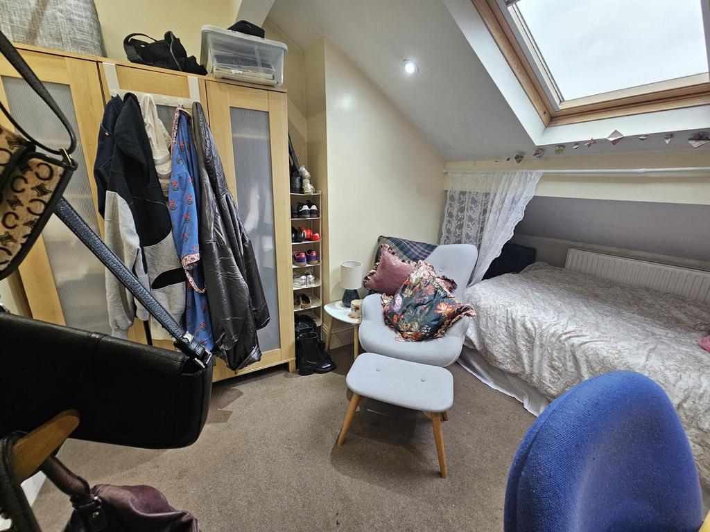 A cozy bedroom featuring a single bed with bedd...