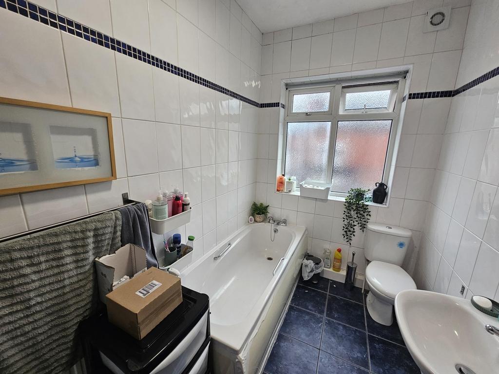 Well-maintained bathroom featuring a large bath...