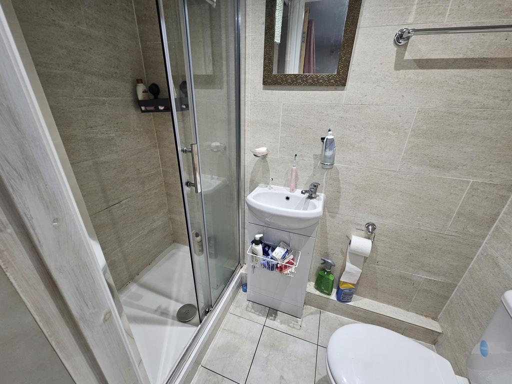 A modern, clean bathroom featuring a glass-encl...