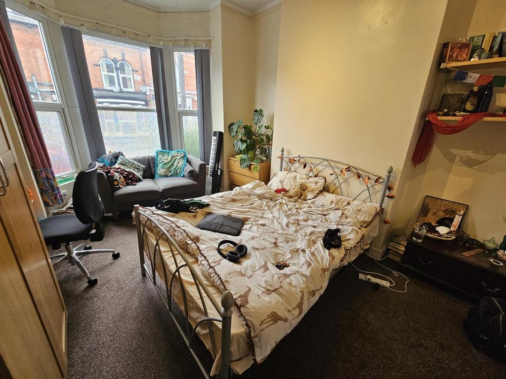 A spacious bedroom featuring a double bed and p...