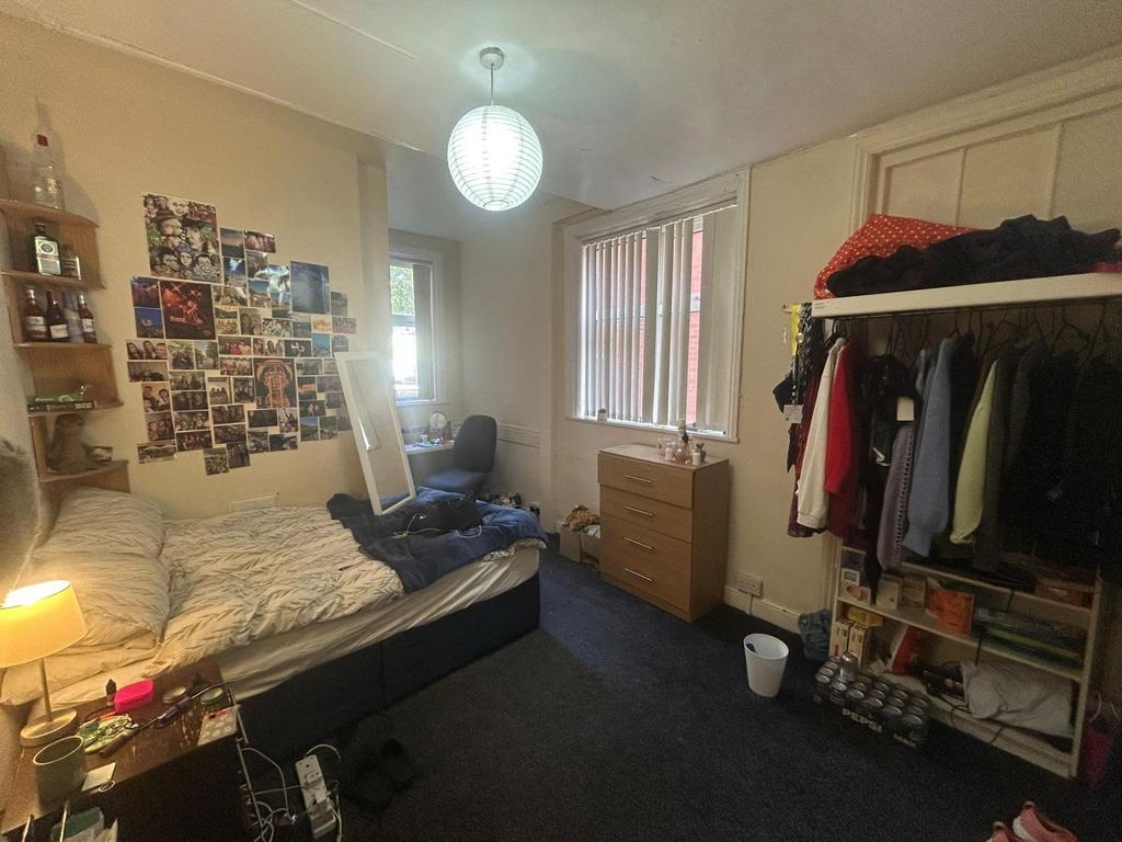 A cozy bedroom with a bed, some personal touche...