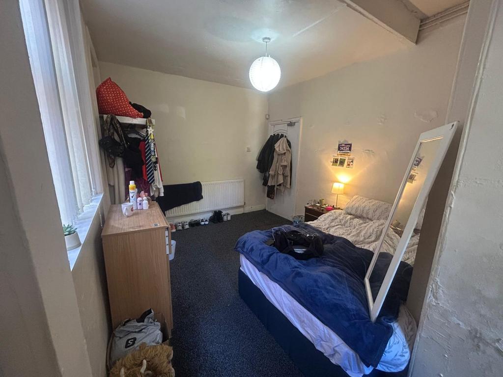 A cozy single bedroom featuring a neatly made b...