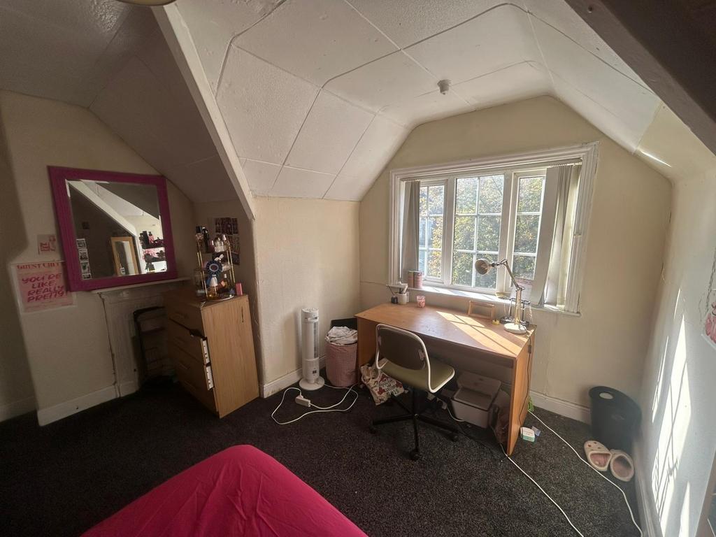 A well-lit bedroom with a large window providin...