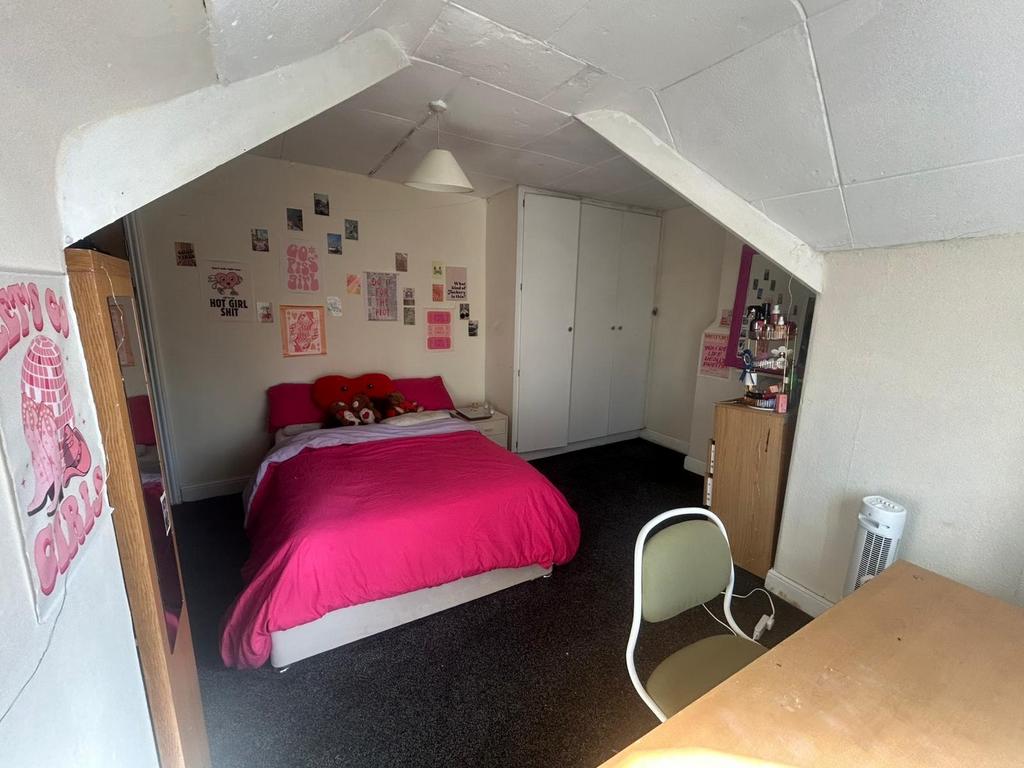 A well-lit double bedroom featuring a cozy bed ...