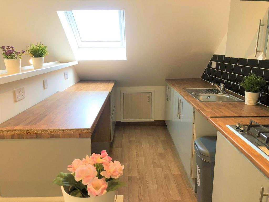 Bright and modern kitchen featuring ample woode...