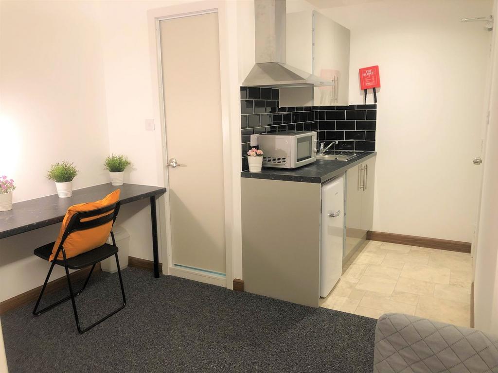 A compact and tidy kitchen area featuring a sma...