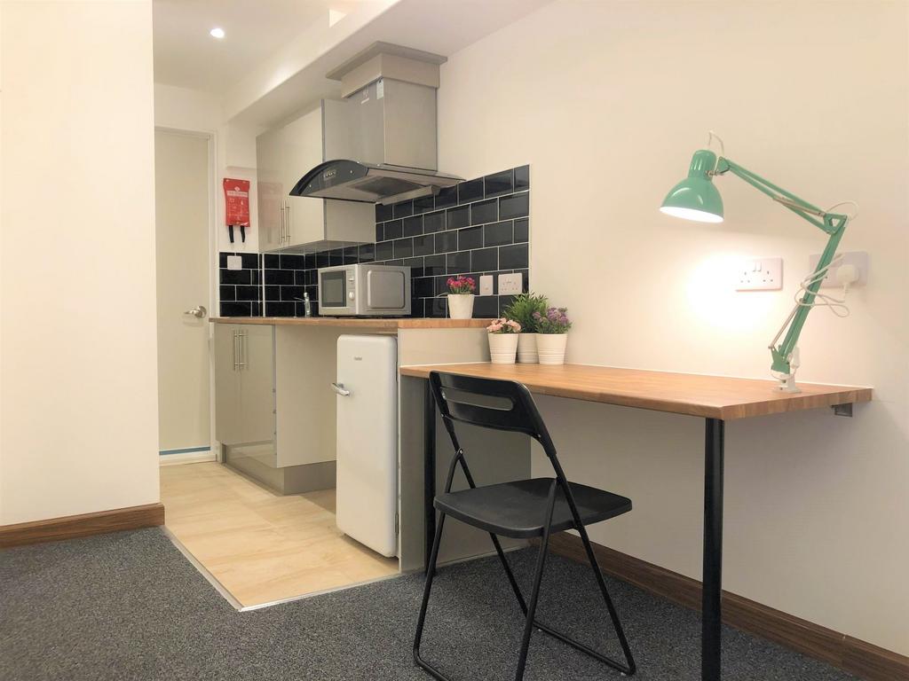 A compact, modern kitchen area featuring a slee...