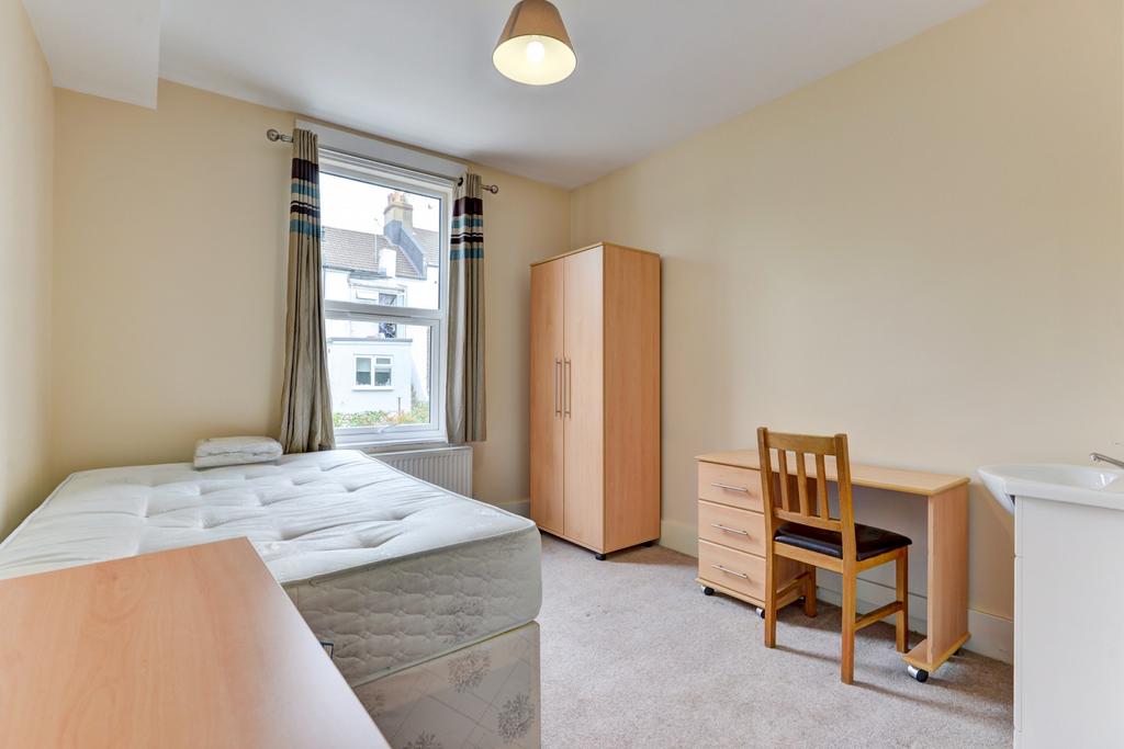 Well-lit bedroom with a comfortable single bed,...