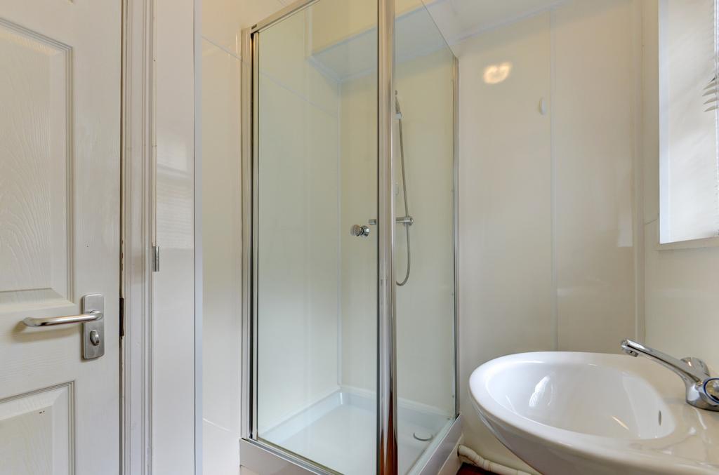 Bright, modern bathroom with a corner glass sho...