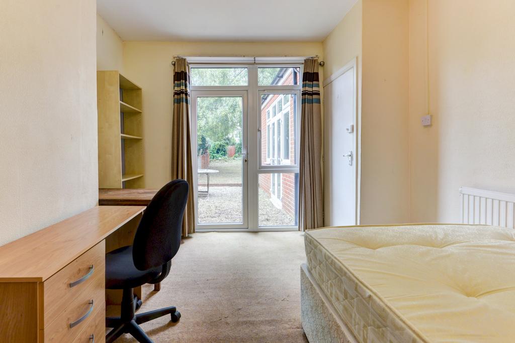 A bright and welcoming bedroom featuring a sing...