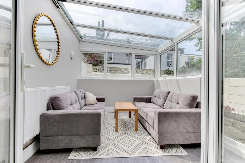 Bright, glass-fronted living room with a vaulte...