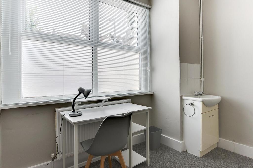 Bright bedroom corner with a large double-heigh...