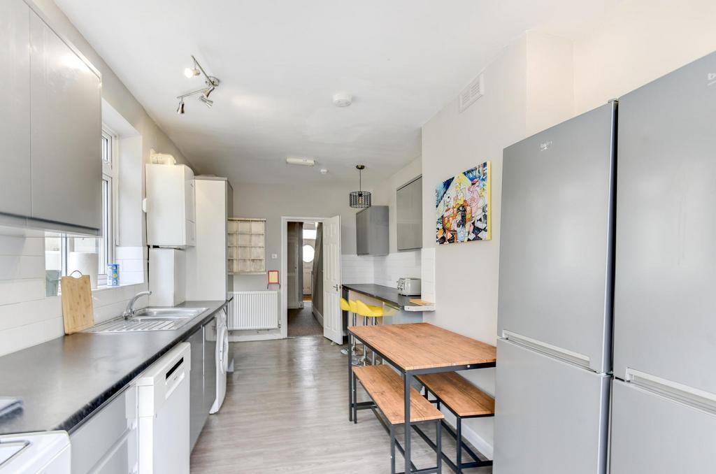 Bright modern galley kitchen with sleek grey ca...