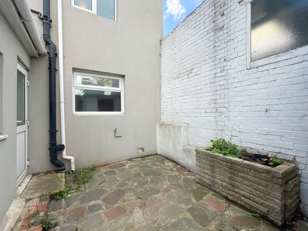 Private paved courtyard with high surrounding w...