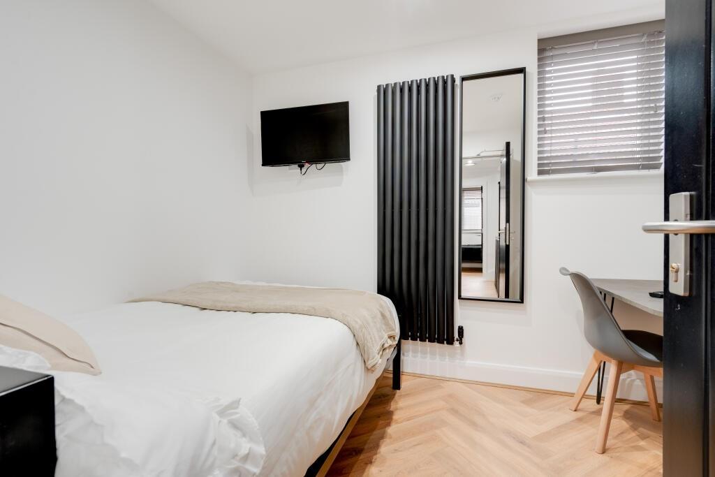 A bright and modern bedroom featuring a comfort...