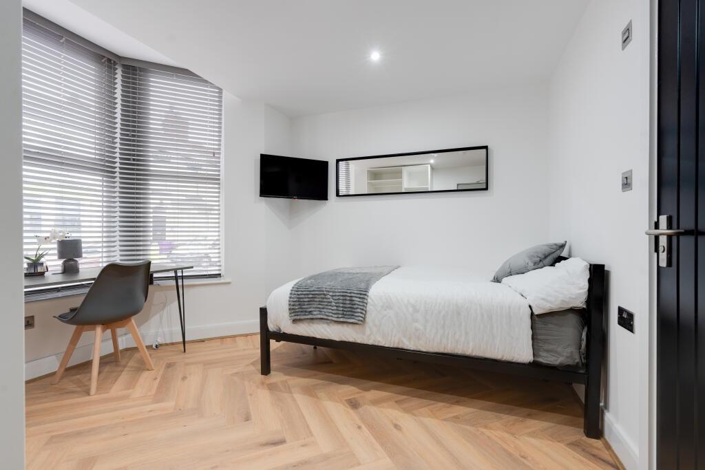 A neatly presented single bedroom featuring a c...