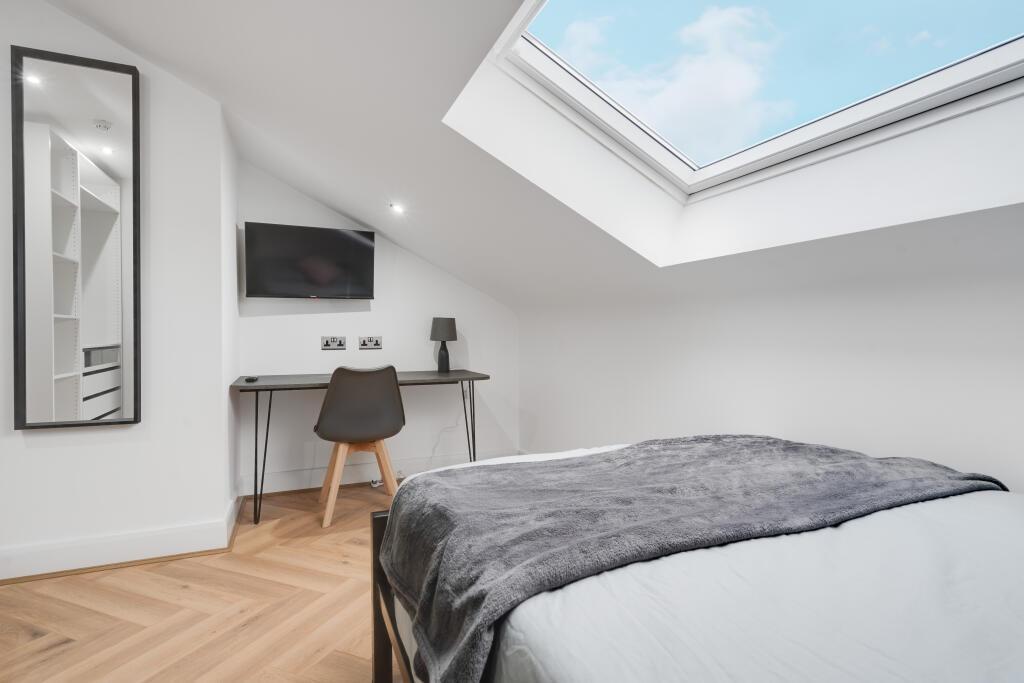 A bright and spacious bedroom featuring a large...