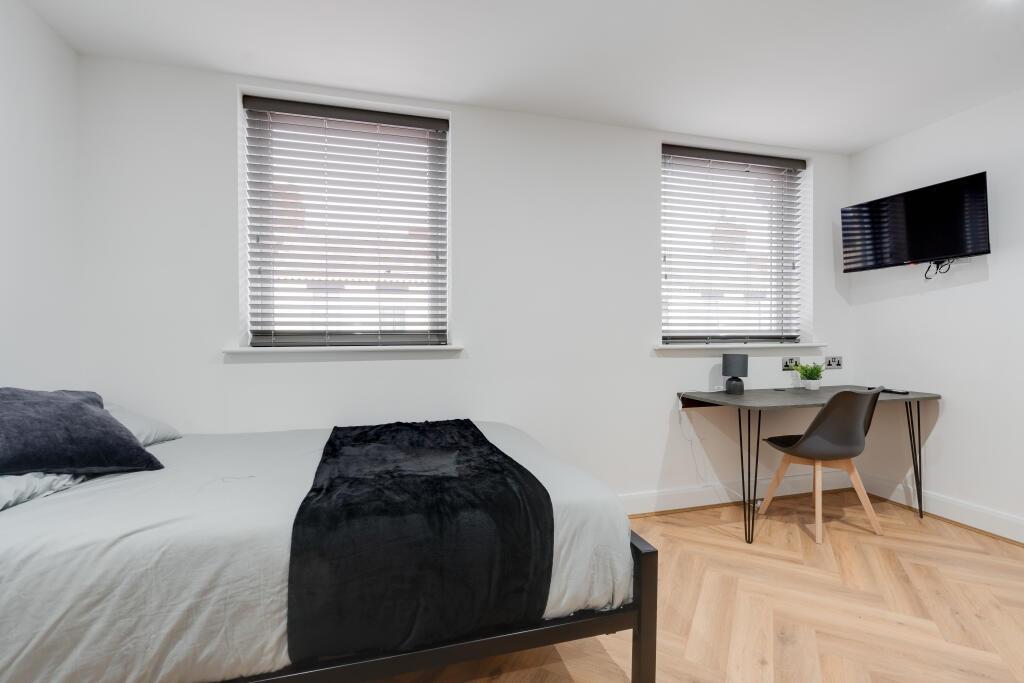 A bright and modern bedroom featuring a double ...