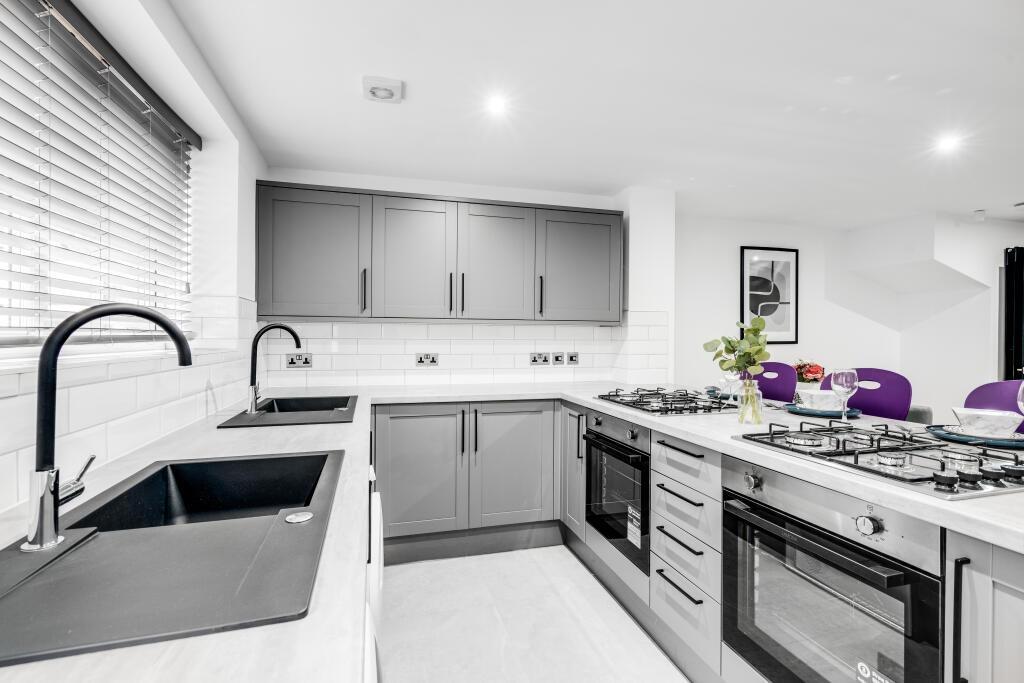 Modern and clean kitchen featuring sleek grey c...