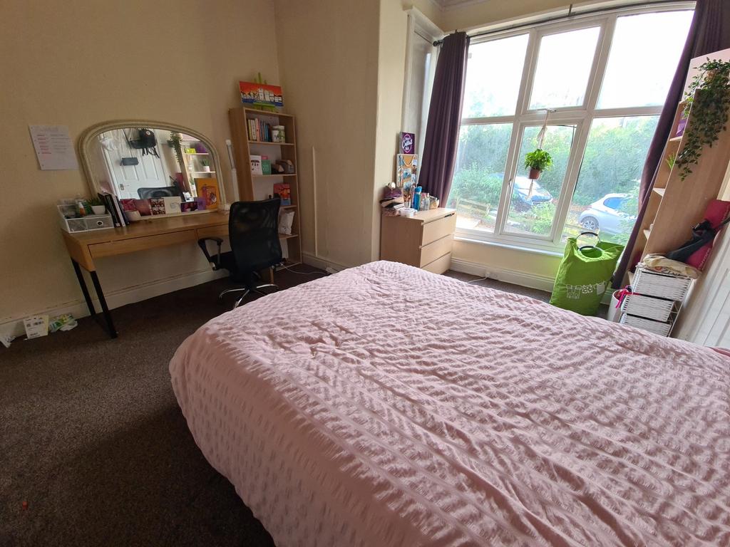 A bright and inviting bedroom featuring a comfo...