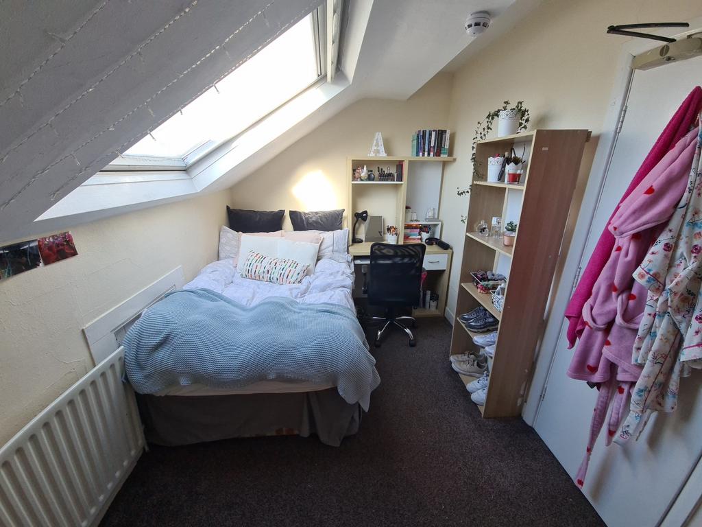 A cozy, well-lit bedroom featuring a double bed...