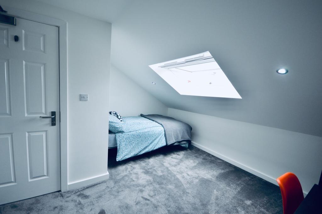 A bright and airy master bedroom featuring a co...