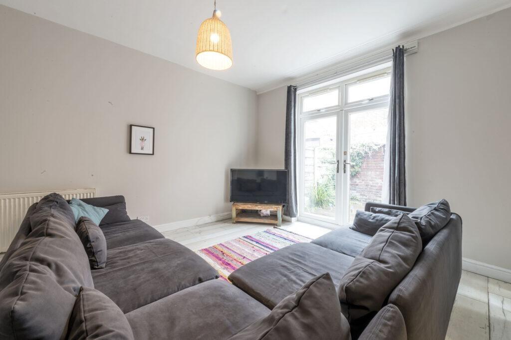 Bright, modern living room with a large L-shape...