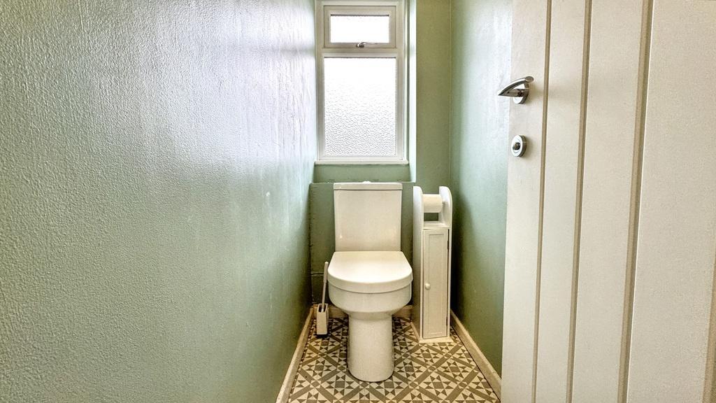 A clean bathroom featuring a standard toilet wi...
