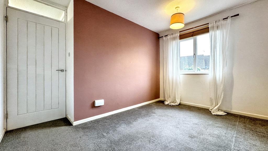 A well-lit, cozy bedroom with a warm pink accen...