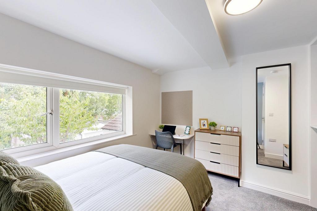 A bright and inviting bedroom featuring a large...