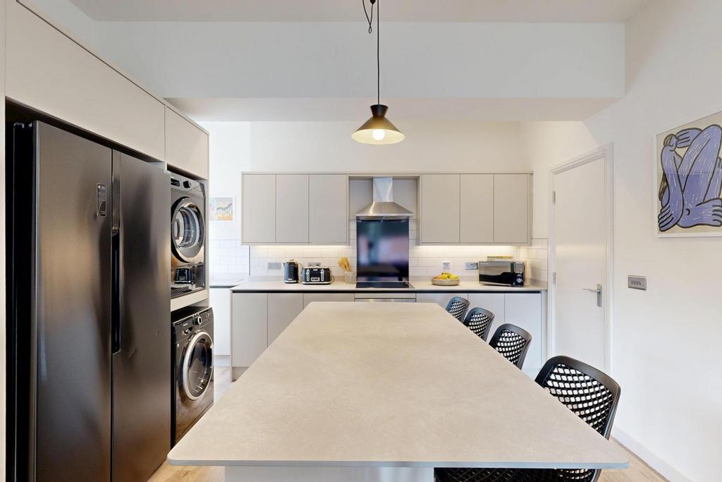 A modern and bright kitchen with clean white ca...