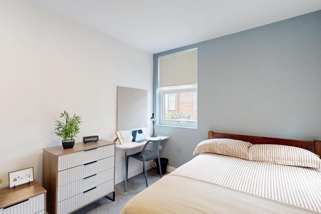 A bright and neatly maintained bedroom featurin...