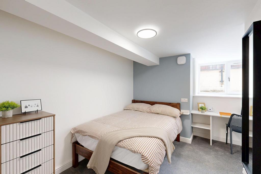 A bright and inviting bedroom featuring a comfo...