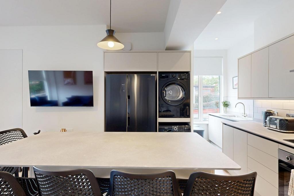 A modern, well-lit kitchen featuring a large ce...