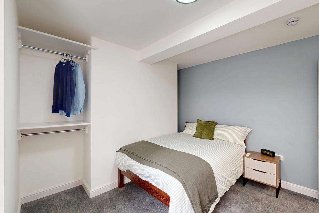 A clean and modern bedroom featuring a comforta...