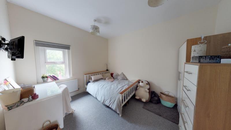 A cozy single bedroom featuring a comfortable b...