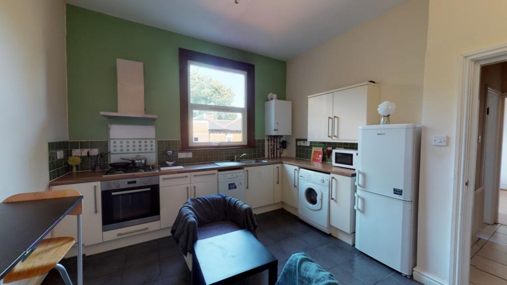 A well-lit kitchen with modern appliances and a...