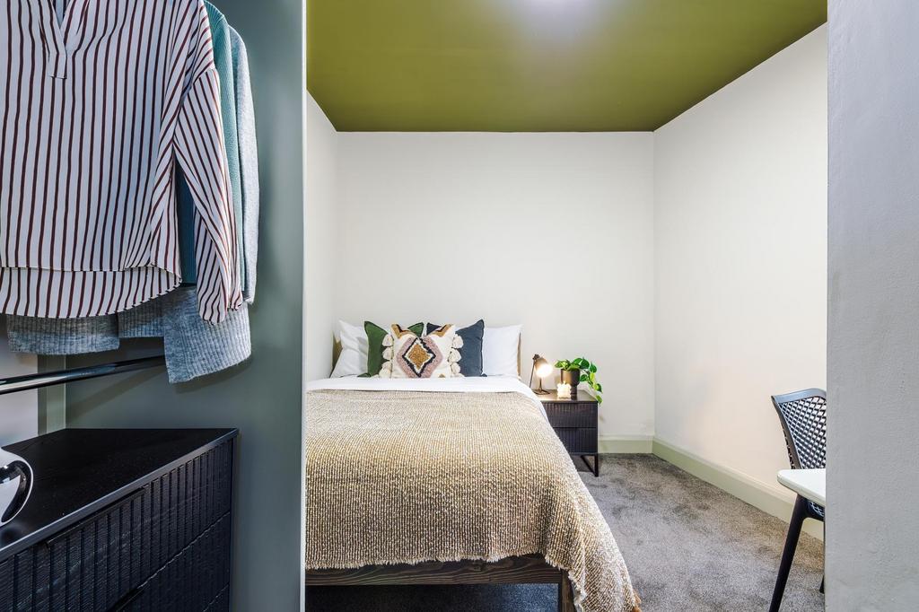 Bright, simply styled double bedroom with a com...