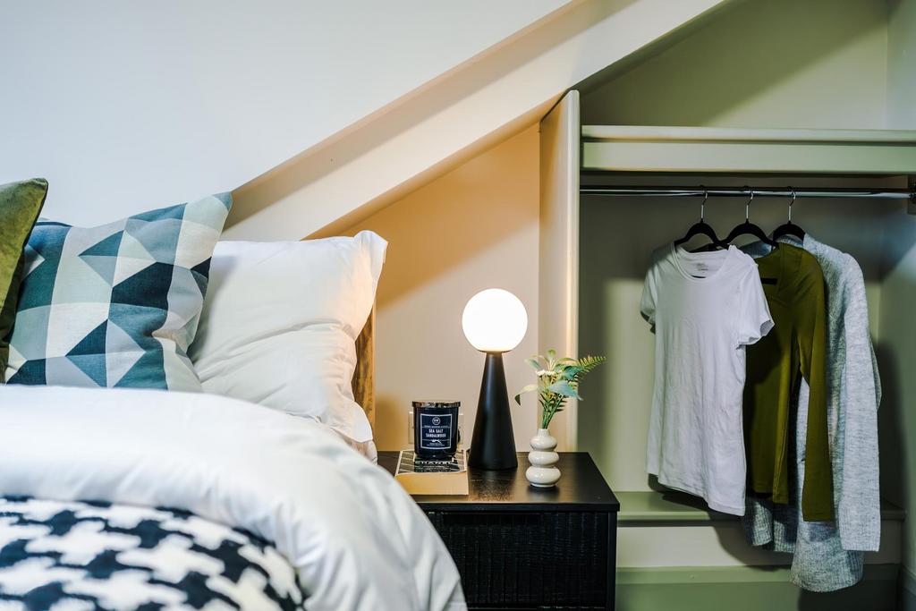 Bright, cozy bedroom with a neatly made bed, pa...