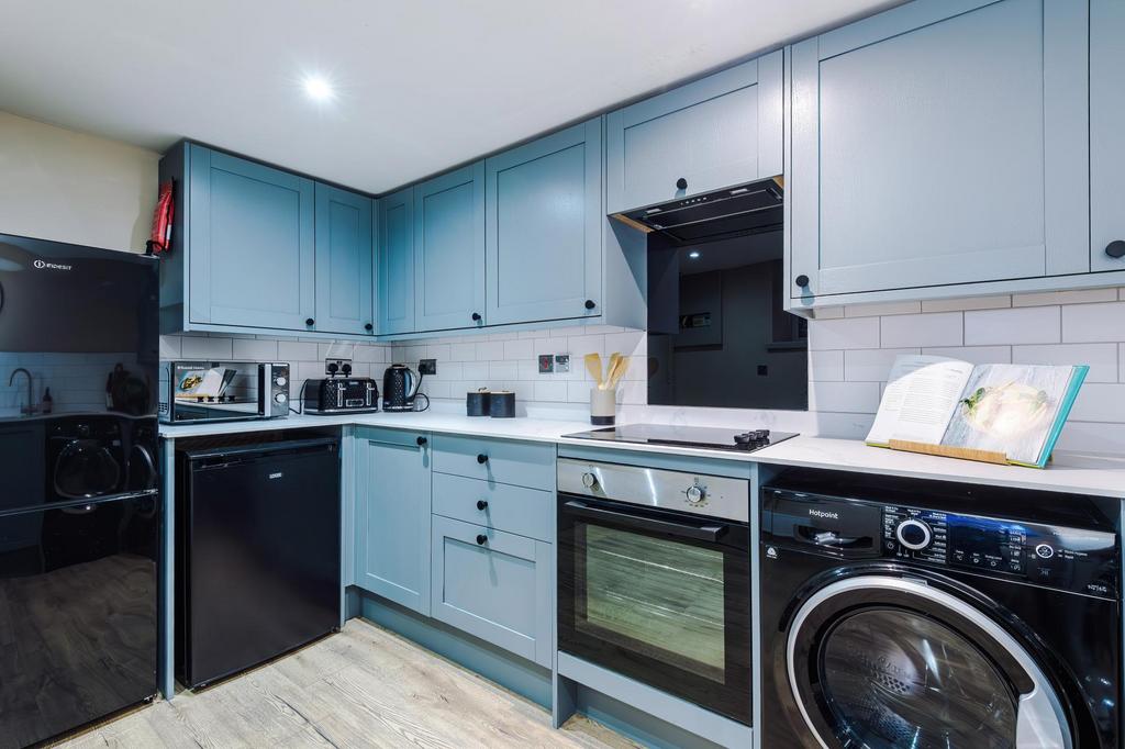 Modern fitted kitchen with blue shaker cabinets...