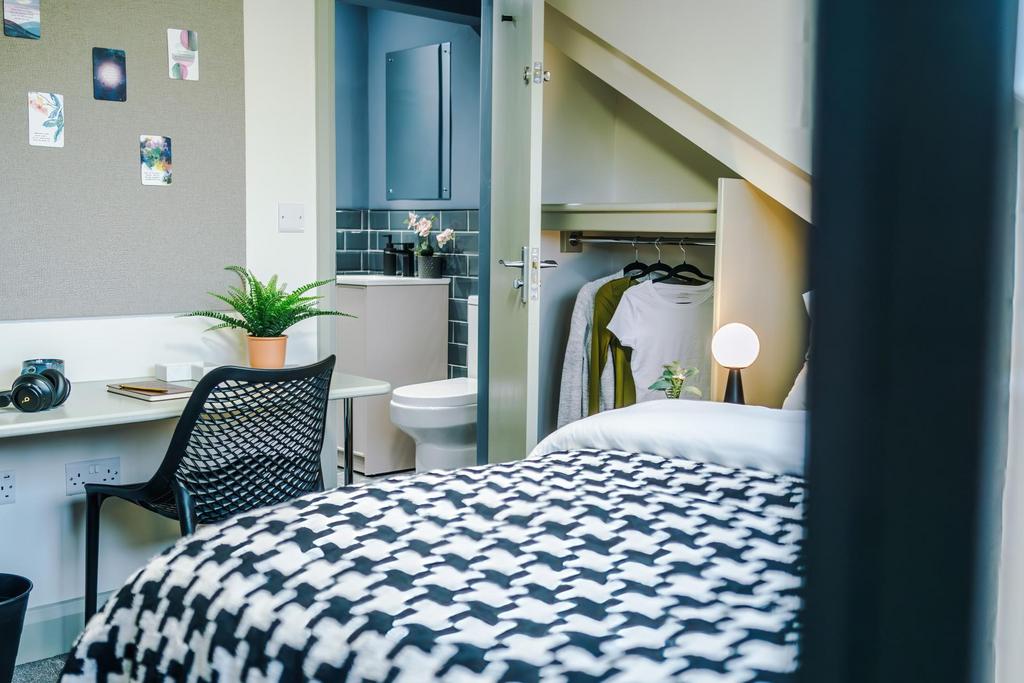 Bright, neatly arranged double bedroom with a p...