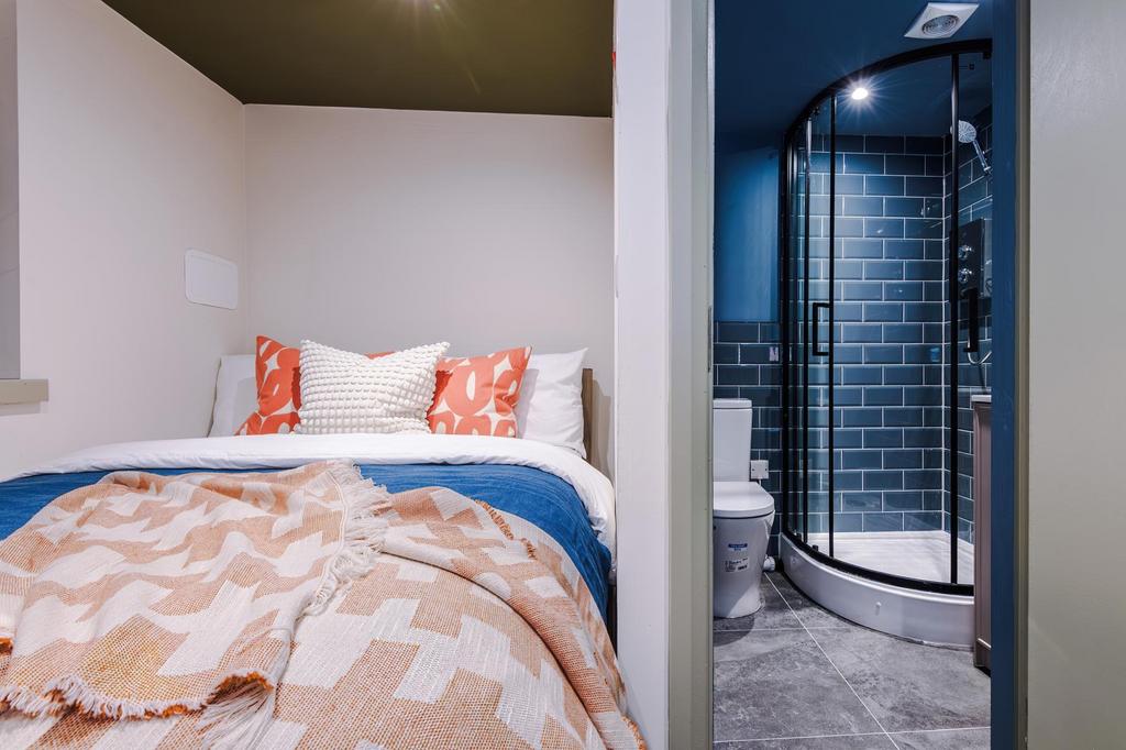 Cozy double bedroom with contemporary bedding a...