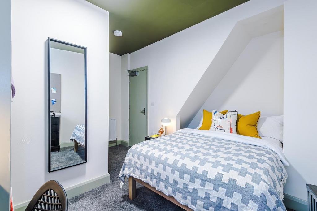 Bright, neatly styled double bedroom with a com...