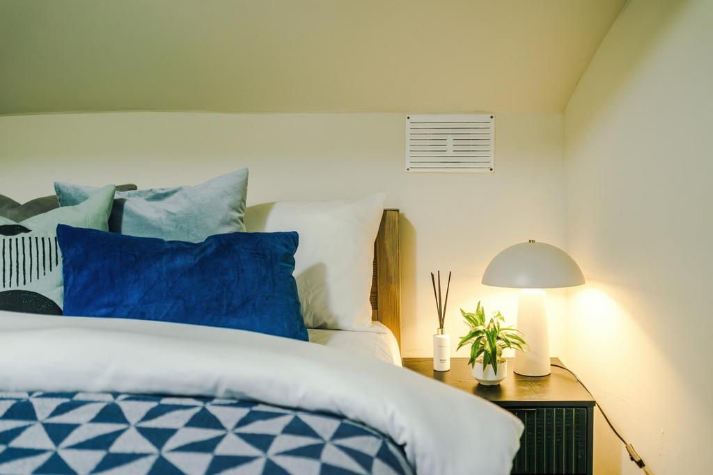 Bright, well-styled bedroom corner with layered...